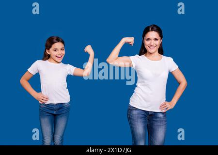 Nahaufnahme Foto zwei Personen Braunhaarige mum Mum kleine Tochter Hand auf bizeps, die Welt Mädchen tragen weiße T-Shirts isoliert hell blau Stockfoto