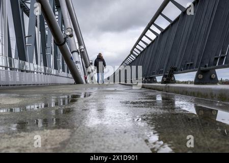 Niederlande, Nijmegen, 16-04-2024, - Fußgänger und Radfahrer müssen mit Wind und Regen auf der Brücke zu kämpfen haben. Es gibt Pfützen und starke Windböen. Foto: ANP/Hollandse Hoogte/ Manon Bruininga netherlands Out - belgien Out Stockfoto