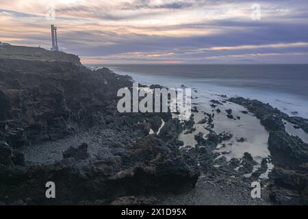 Vulkanische Landschaft und Ozean mit dem Leuchtturm Buenavista, mit dem letzten Licht des Tages, kurz vor Einbruch der Dunkelheit, Teneriffa, Kanarische Inseln Stockfoto