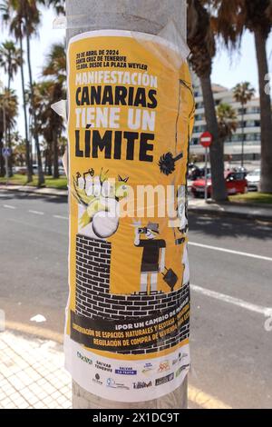 Los Cristianos, Teneriffa, 16. April 2024 - Touristen laufen an Anti-Touristen-Plakaten entlang der Strandfront in Los Cristianos vorbei. Auf dem Poster steht, dass die Kanarischen Inseln eine Grenze haben. Die gelben Schilder werben für den anti-touristischen Protest am Samstag, den 20. April. In Santa Cruz de Teneriffa. Parken ist auch ein großes Problem in der Gegend, da unzählige Besucher Tausende von Plätzen füllen, was für die Bewohner und Besucher gleichermaßen Kopfschmerzen bereitet. Quelle: Stop Press Media/Alamy Live News Stockfoto