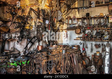 Das Innere einer Schmiedewerkstatt mit hängenden Gegenständen aus Schmiedeeisen und Kupfer. Guardiagrele, Provinz Chieti, Abruzzen, Italien, Europa Stockfoto