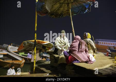 Pujari- oder Hindu-Priester führen in der Vordämmerung Rituale für Pilger auf dem Ufer des Ganges bei Varanasi, Indien, durch. Stockfoto