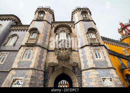 Eine Statue der Triton-Wachen am Eingang zum Nationalpalast Pena (Palacio Nacional da Pena), Sintra, Bezirk Lissabon, Portugal. Triton-Bogensym Stockfoto