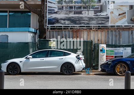 Tesla Fahrzeug lädt seine Batterien an einer Ladestation oder an einer elektrischen Station an einem sonnigen Tag in Lissabon auf Stockfoto