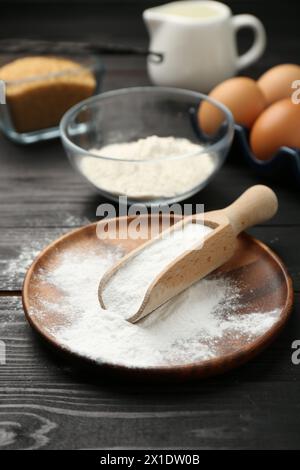 Backpulver und andere Produkte auf schwarzem Holztisch Stockfoto