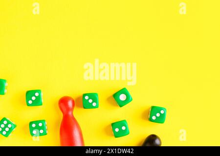 Viele grüne Würfel und Farbspielsteine auf gelbem Hintergrund, flache Lagen Stockfoto