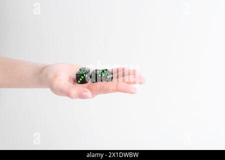 Frau, die Spielwürfel in der Hand auf weißem Hintergrund hält, Nahaufnahme Stockfoto