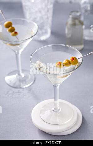 Martini mit Oliven- und Salamigarnituren, schmutziger Martini-Cocktail in einem traditionellen Glas Stockfoto