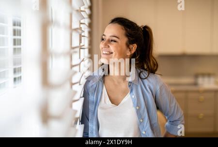 Porträt einer schönen jungen Frau, die zu Hause in der Küche steht Stockfoto