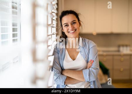 Porträt einer schönen jungen Frau, die zu Hause in der Küche steht Stockfoto