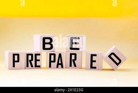 Bereiten Sie Wörter vor, die auf einem Holzblock mit gelbem Hintergrund geschrieben sind. Konzeptsymbol. Kopierbereich. Stockfoto