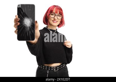 Junge Frau mit rotem Haar, die ein Smartphone mit einem kaputten Bildschirm auf weißem Hintergrund hält Stockfoto