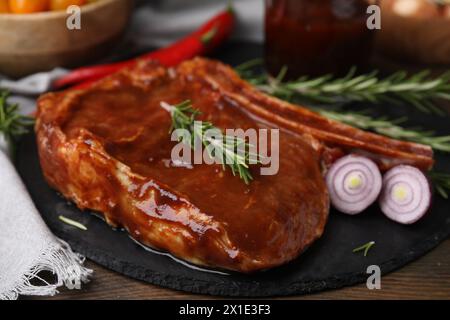 Leckeres mariniertes Fleisch, Rosmarin und Zwiebeln auf Holztisch, Nahaufnahme Stockfoto