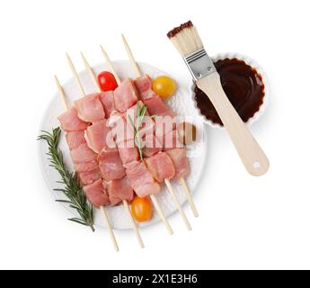 Spieße mit rohen Fleischstücken, Rosmarin, Tomaten und Marinade isoliert auf weiß, Blick von oben Stockfoto