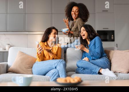 Zwangloser Moment Freundinnen lachen und trinken Kaffee Stockfoto