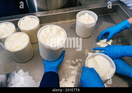 Abfüllformen für die Herstellung von Weichkäse. Die Käselochen sind in Salzlake getränkt. Ausgewählter Fokus. Hochwertige Fotos Stockfoto