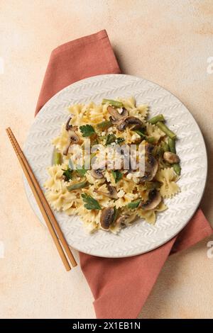Vegetarische Pasta mit Pilzen, Petersilie, Bohnen und Käse auf orangefarbenem Tisch, Blick von oben Stockfoto
