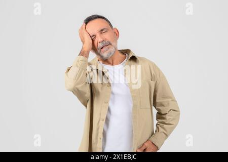 Senior mit Kopfschmerzen oder Stressreaktion auf weiß Stockfoto