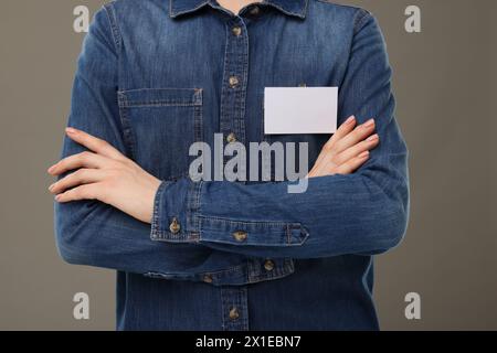 Frau mit leerem Abzeichen auf grauem Hintergrund, Nahaufnahme Stockfoto