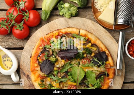 Köstliche vegetarische Pizza und Zutaten auf Holztisch, flach gelegen Stockfoto