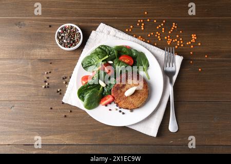 Leckeres vegetarisches Kotelett mit Gemüse auf Holztisch, flach gelegt Stockfoto