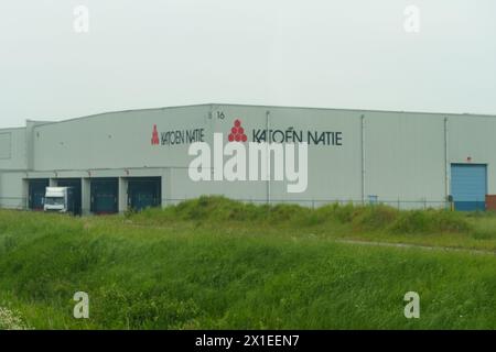 Gent, Belgien - 22. Mai 2023: Das Äußere eines großen, industriellen Lagers mit Firmenlogos, einer Laderampe und einem grasbewachsenen Vorfeld Stockfoto