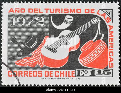 Gestempelte Briefmarke, gedruckt von Chile, die Gitarre und irdenes Jar zeigt, Jahr des amerikanischen Tourismus, um 1972. Stockfoto