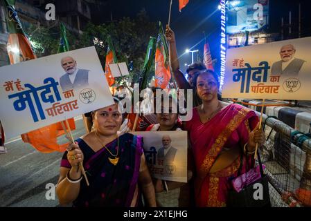 Anhänger der Bharatiya Janata Party (BJP) halten ein Plakat in der Hand, während sie auf die Straßenausstellung von Narendra Modi während eines Wahlkampfes in Guwahati, Assam, Indien am 16. April 2024 warteten. Quelle: David Talukdar/Alamy Live News Stockfoto