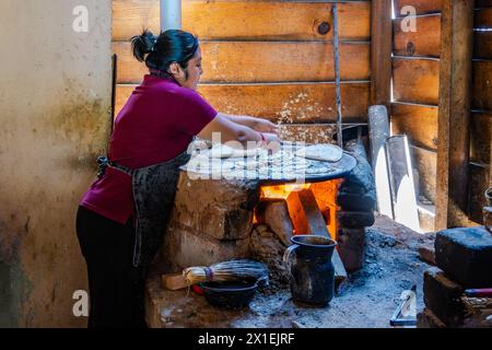 Eine Frau, die Maistortilla auf einem traditionellen, flachen Herd kocht. Oaxaca, Mexiko. Stockfoto