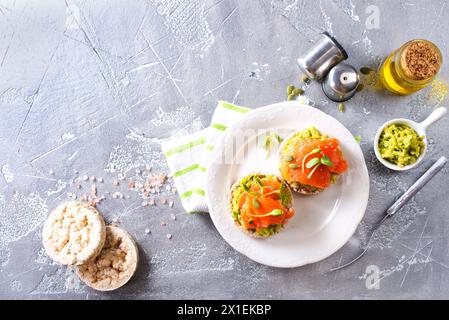 Sandwiches mit Lachs und Avocado auf weißem Teller Stockfoto