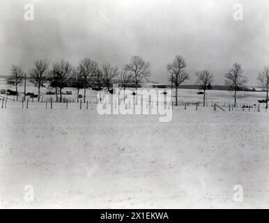 Fotos des Zweiten Weltkriegs: Originalunterschrift: General Pattons gepanzerte Truppen, die 101 Luftlandemänner entlastet haben, die Bastogne zehn Tage lang hielten, beginnen ihre Fahrt über Bastogne hinaus. In der Mitte des Fotos explodiert die deutsche Artillerie." CA. Dezember 1944 Stockfoto