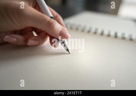 Die Hand einer Frau, die einen Stift auf dem Notizbuch hält. Bildungs- und Arbeitskonzept. Stockfoto