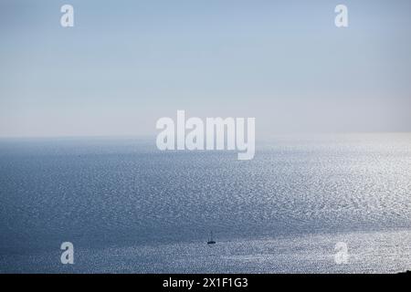 Ein kleines Segelboot segelt auf der Meeresoberfläche der Adria. Balkan. Blick von oben. Montenegro. Budva. Horizontal. Stockfoto