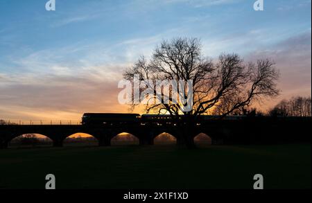 Lokomotive Services Diesellokomotive der Baureihe 47 überquert das Melling-Viadukt auf der kleinen Nordwestlinie und bildet mit einem Charterzug eine Silhouette bei Sonnenuntergang Stockfoto