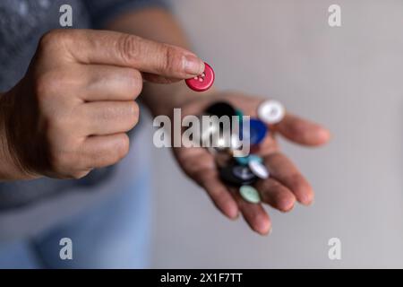 Schneiderhand zeigt einen Knopf Stockfoto