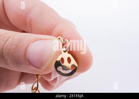 Goldene Farbe Smileys aufgereiht an einer Kette in der hand Stockfoto