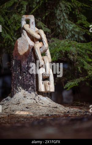 Aus einem Baumstumpf wird eine Kette mit Sägemehl auf dem Boden geschnitzt. Die Szene ist friedlich und ruhig. Stockfoto