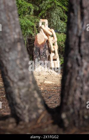 Aus einem Baumstumpf wird eine Kette mit Sägemehl auf dem Boden geschnitzt. Die Szene ist friedlich und ruhig. Stockfoto