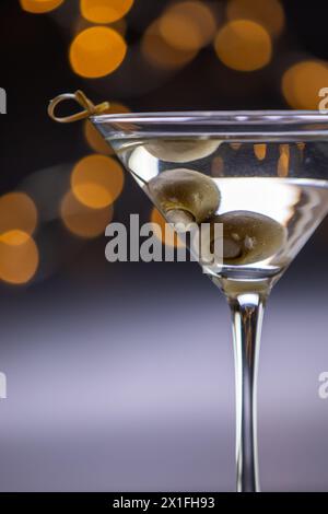 Ein Martini-Glas mit Oliven darin. Die Oliven marinieren im Getränk und das Glas ist voll Stockfoto