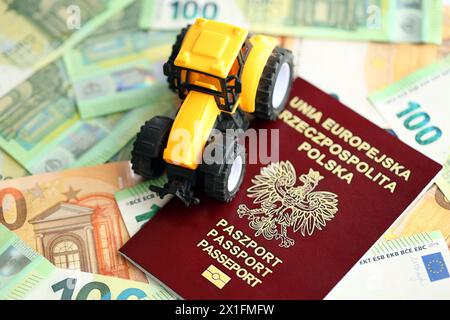 Roter polnischer Pass und gelber Traktor auf Euro-Geldscheinen aus nächster Nähe Stockfoto