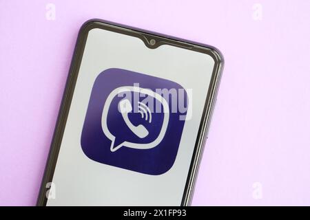 KIEW, UKRAINE - 1. APRIL 2024 Viber Messenger-Symbol auf Smartphone-Bildschirm auf lila Tisch Nahaufnahme. IPhone-Display mit App-Logo auf lilafarbenem Hintergrund Stockfoto