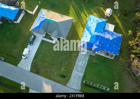 Luftaufnahme beschädigter Dächer im Hurrikan Ian beherbergt Dächer mit blauer Schutzplane gegen Regenwasseraustritt bis zum Asphaltaustausch Stockfoto