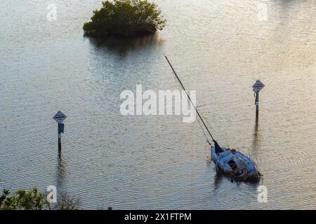 Halb versunkene Segelyacht kenterte in flachen Gewässern der Bucht nach dem Hurrikan Ian in Manasota, Florida Stockfoto