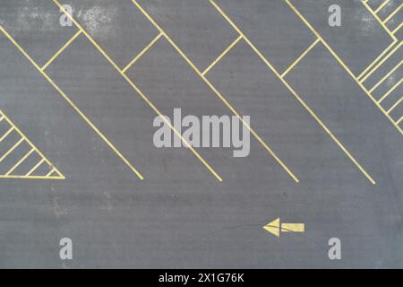 Asphaltparkplatz mit gelben Linien und nach links zeigendem Pfeil Stockfoto