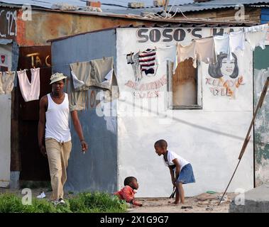 Township Khayelitsha, die drittgrößte und am schnellsten wachsende Township Südafrikas, am Stadtrand von Kapstadt in den Cape Flats, erobert am 5. Juli 2010. Auf dem Bild: Bewohner vor ihrer Hütte. - 20100705 PD2333 - Rechteinfo: Rechte verwaltet (RM) Stockfoto