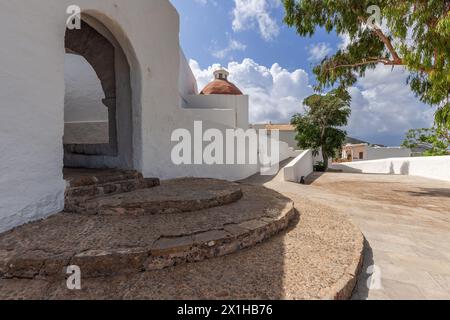 Ein fesselnder Blick auf Puig de Missa in Santa Eulalia, Ibiza, mit seiner berühmten weißen Architektur, runden Steintreppen und Terrakotta-Kuppel, eingebettet Stockfoto