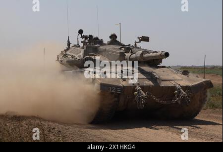 Ein israelischer Merkava-Panzer rollt entlang der Grenze zwischen Israel und dem Gazastreifen, als er aus dem Gazastreifen zurückkehrt, während die Kämpfe zwischen Israel und der militanten Gruppe Hamas am 16. April 2024 an der Grenze zu Gaza, Israel. Stockfoto