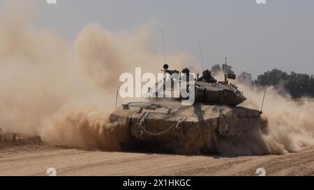 Ein israelischer Merkava-Panzer rollt entlang der Grenze zwischen Israel und dem Gazastreifen, als er aus dem Gazastreifen zurückkehrt, während die Kämpfe zwischen Israel und der militanten Gruppe Hamas am 16. April 2024 an der Grenze zu Gaza, Israel. Stockfoto