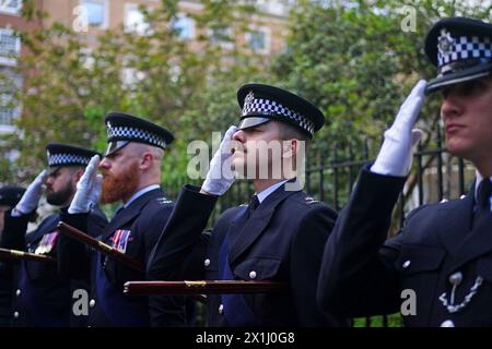 Metropolitan Police Officers in Uniform grüßen während einer Gedenkfeier zum 40. Jahrestag für PC Yvonne Fletcher am St James's Square, London. PC Fletcher wurde am 17. April 1984 durch einen Schuss der libyschen Botschaft auf dem St James’s Square, London, ermordet, nachdem sie zur Überwachung einer Demonstration gegen den damaligen libyschen Führer Muammar Gaddafi eingesetzt worden war. Bilddatum: Mittwoch, 17. April 2024. Stockfoto