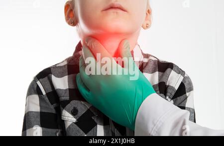 Die Hand eines Endokrinologen palpiert die Schilddrüse eines siebenjährigen Mädchens. Das Konzept der Dysfunktion der Schilddrüsenhormone. Jodmangel, Schilddrüse Stockfoto